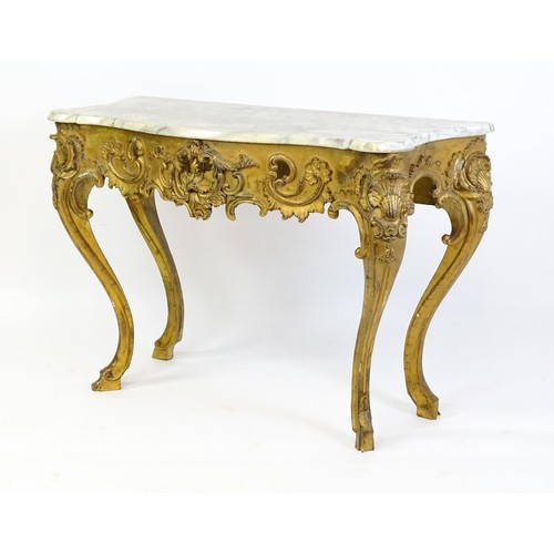 1573 - A 19thC marble topped table with a gesso and giltwood moulded base, decorated with shells, flowers, ... 