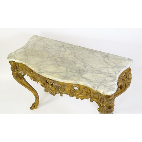 1573 - A 19thC marble topped table with a gesso and giltwood moulded base, decorated with shells, flowers, ... 