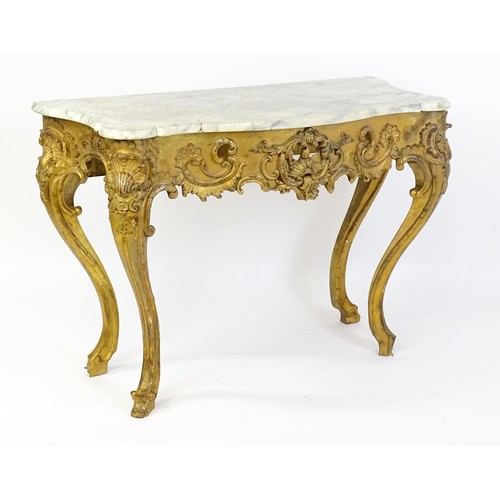 1573 - A 19thC marble topped table with a gesso and giltwood moulded base, decorated with shells, flowers, ... 