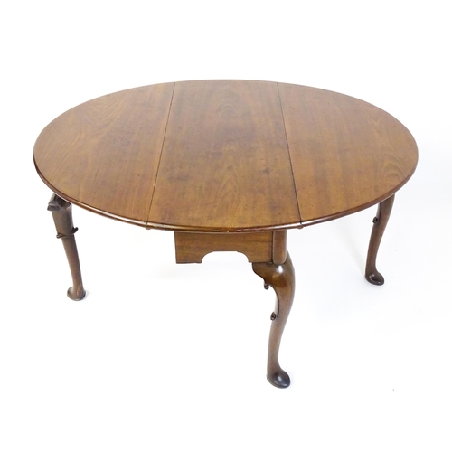 1597 - A late 18thC mahogany drop leaf table, opening to form an oval dining table and raised on four cabri... 