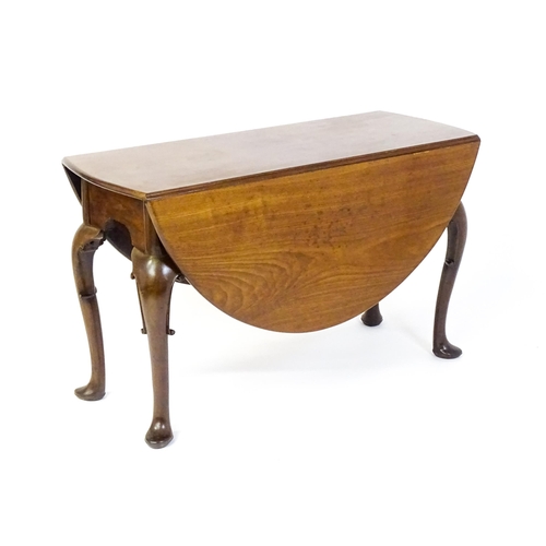 1597 - A late 18thC mahogany drop leaf table, opening to form an oval dining table and raised on four cabri... 