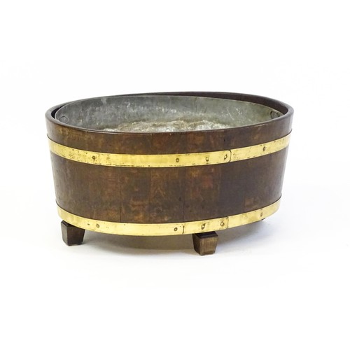 1608 - A late Georgian oak wine cooler / cellarette with a coopered and brass strapped frame and raised on ... 