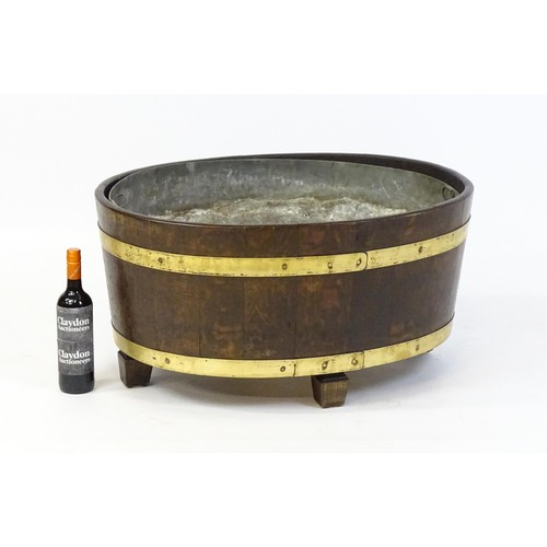 1608 - A late Georgian oak wine cooler / cellarette with a coopered and brass strapped frame and raised on ... 