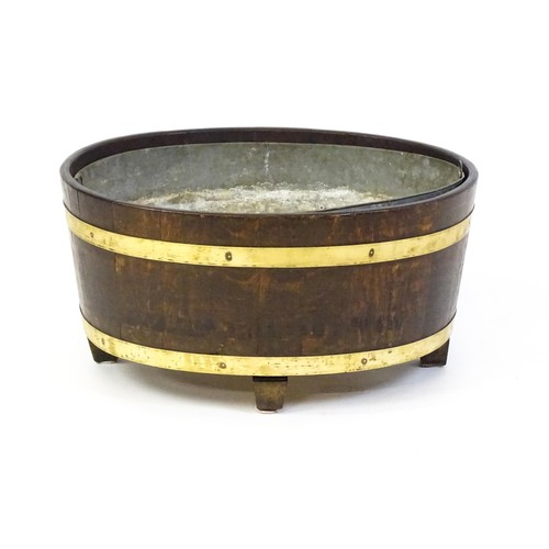 1608 - A late Georgian oak wine cooler / cellarette with a coopered and brass strapped frame and raised on ... 