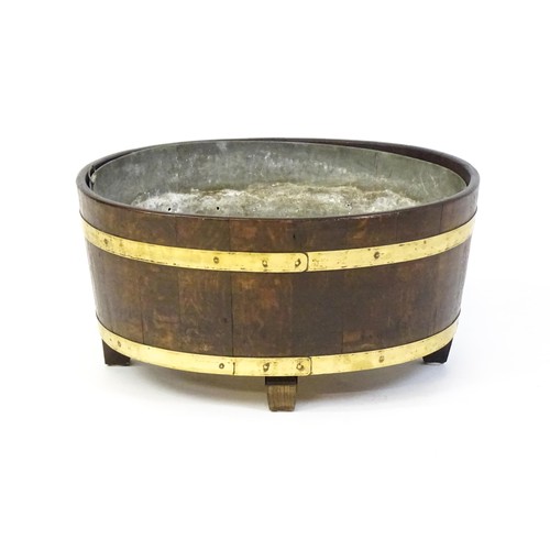 1608 - A late Georgian oak wine cooler / cellarette with a coopered and brass strapped frame and raised on ... 