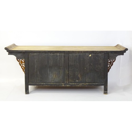 1659 - A mid 20thC oriental sideboard with a planked top, shaped ends and pierced brackets to either side w... 