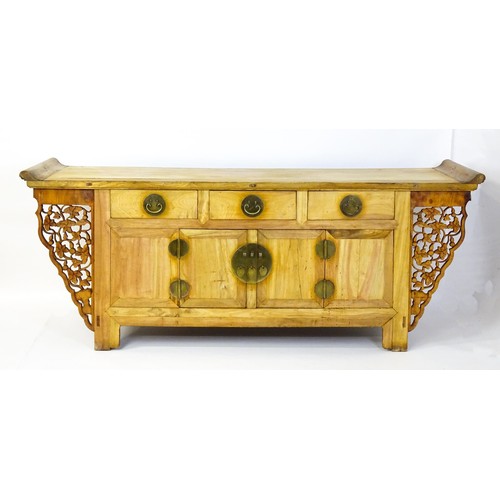 1659 - A mid 20thC oriental sideboard with a planked top, shaped ends and pierced brackets to either side w... 