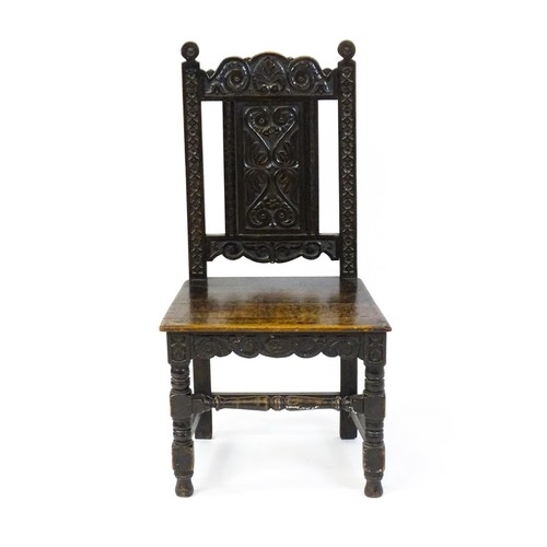 1662 - A 19thC carved oak side chair with floral carving, a planked seat and raised on block and turned leg... 