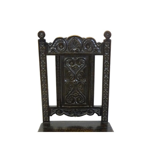 1662 - A 19thC carved oak side chair with floral carving, a planked seat and raised on block and turned leg... 