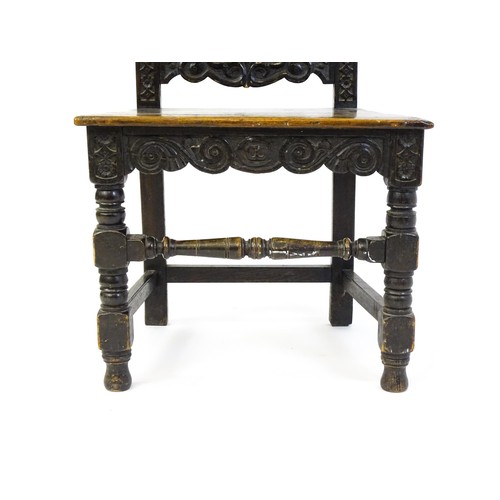 1662 - A 19thC carved oak side chair with floral carving, a planked seat and raised on block and turned leg... 