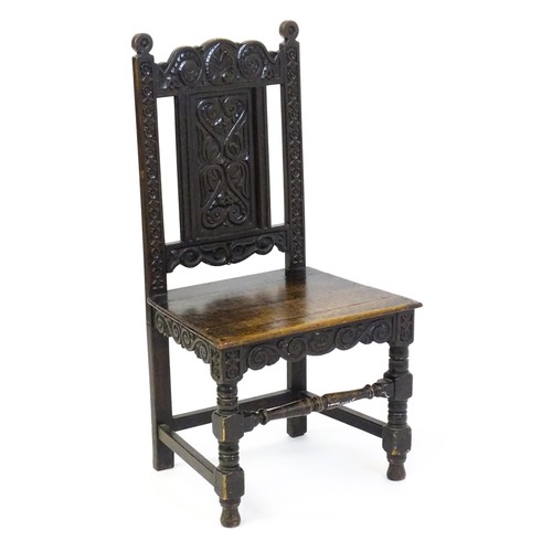 1662 - A 19thC carved oak side chair with floral carving, a planked seat and raised on block and turned leg... 