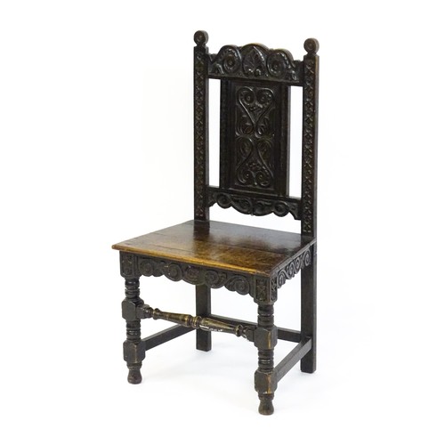 1662 - A 19thC carved oak side chair with floral carving, a planked seat and raised on block and turned leg... 