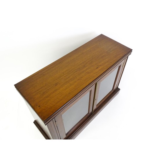 1665 - A 19thC mahogany glazed bookcase with a moulded top above two glazed doors and a stepped base. 45