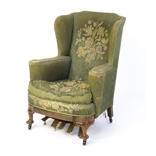 1689 - A 19thC wingback armchair for re-upholstery, the chair raised on walnut cabriole front legs and bloc... 