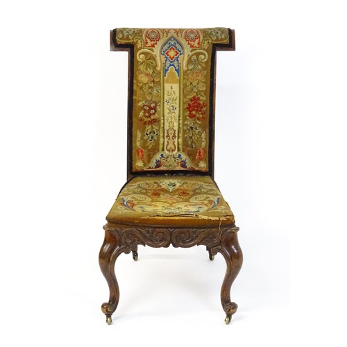 1691 - A mid 19thC rosewood prie-dieu with needlework upholstery, scrolled carved detailing to the seat rai... 