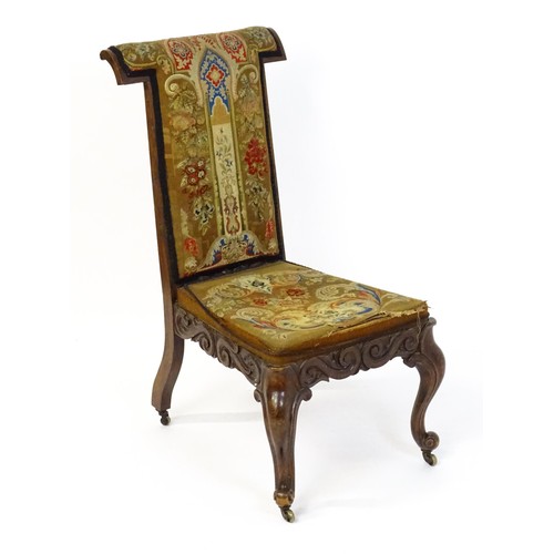 1691 - A mid 19thC rosewood prie-dieu with needlework upholstery, scrolled carved detailing to the seat rai... 