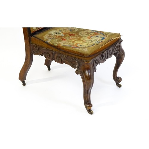 1691 - A mid 19thC rosewood prie-dieu with needlework upholstery, scrolled carved detailing to the seat rai... 