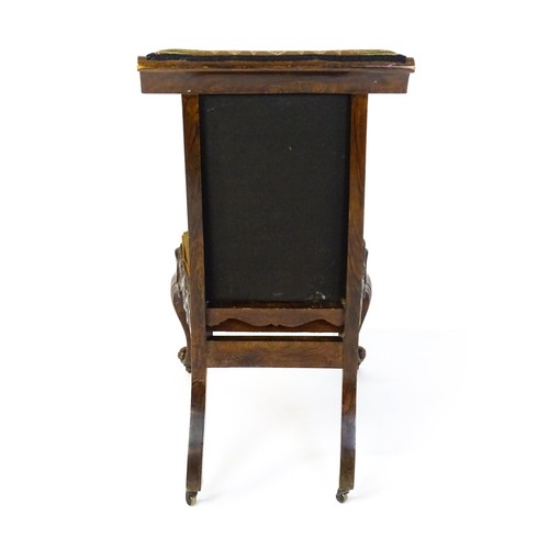 1691 - A mid 19thC rosewood prie-dieu with needlework upholstery, scrolled carved detailing to the seat rai... 