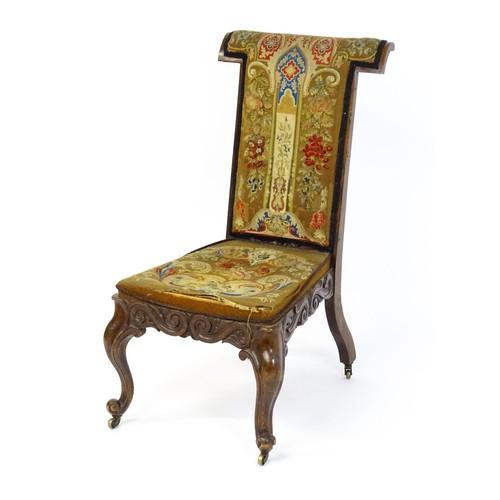 1691 - A mid 19thC rosewood prie-dieu with needlework upholstery, scrolled carved detailing to the seat rai... 