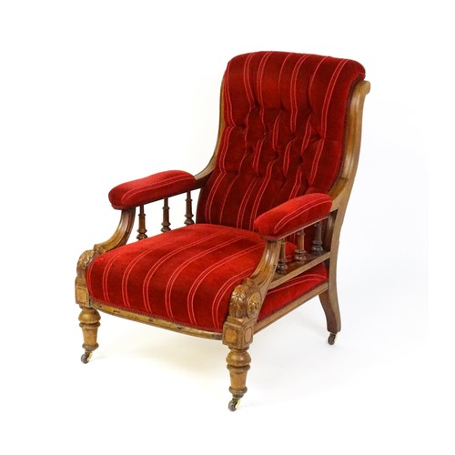 1692 - A late 19thC mahogany armchair, with deep buttoned upholstery and manchettes raised on turned taperi... 