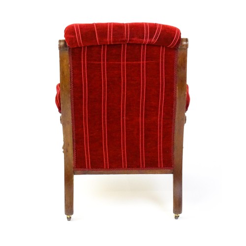 1692 - A late 19thC mahogany armchair, with deep buttoned upholstery and manchettes raised on turned taperi... 