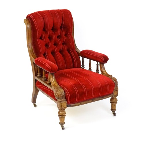 1692 - A late 19thC mahogany armchair, with deep buttoned upholstery and manchettes raised on turned taperi... 