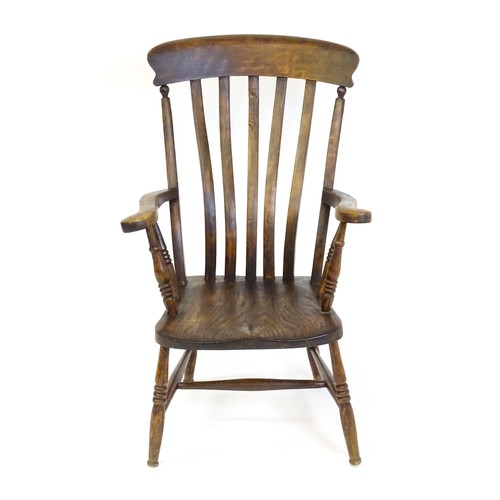 1697 - A late 19thC / early 20thC lathe back Windsor chair, with a bowed top rail, slatted back slats, a sh... 