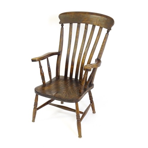 1697 - A late 19thC / early 20thC lathe back Windsor chair, with a bowed top rail, slatted back slats, a sh... 