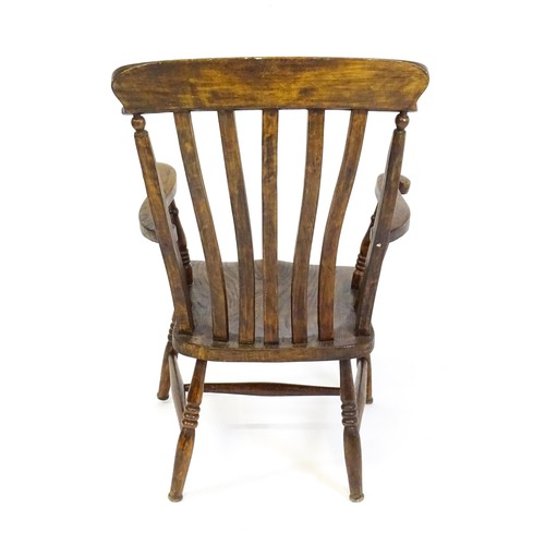 1697 - A late 19thC / early 20thC lathe back Windsor chair, with a bowed top rail, slatted back slats, a sh... 