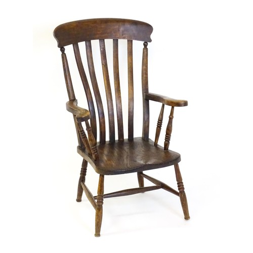 1697 - A late 19thC / early 20thC lathe back Windsor chair, with a bowed top rail, slatted back slats, a sh... 