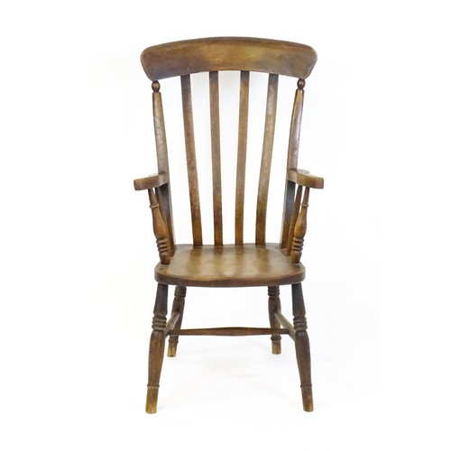 1698 - A late 19thC lathe back Windsor chair with swept arms above a shaped elm seat and raised on turned t... 