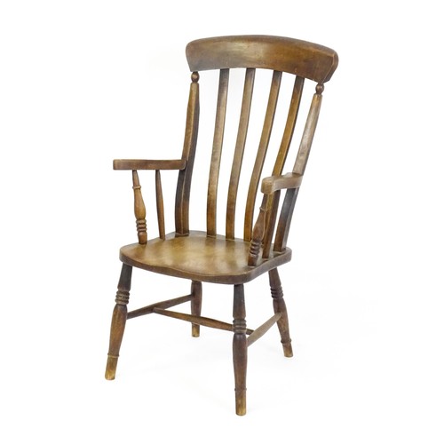 1698 - A late 19thC lathe back Windsor chair with swept arms above a shaped elm seat and raised on turned t... 