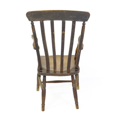 1698 - A late 19thC lathe back Windsor chair with swept arms above a shaped elm seat and raised on turned t... 