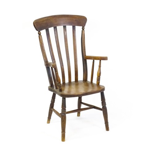 1698 - A late 19thC lathe back Windsor chair with swept arms above a shaped elm seat and raised on turned t... 