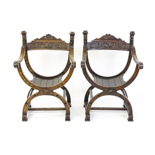 1703 - Two late 19thC / early 20thC Savonarola chairs, the uprights of scrolled form with carved mask detai... 