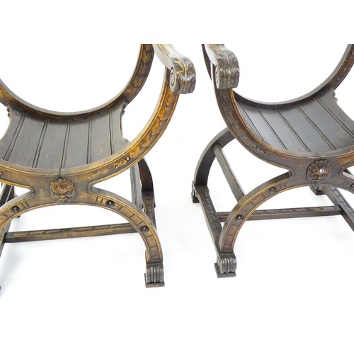 1703 - Two late 19thC / early 20thC Savonarola chairs, the uprights of scrolled form with carved mask detai... 