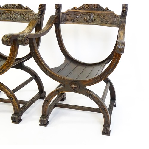 1703 - Two late 19thC / early 20thC Savonarola chairs, the uprights of scrolled form with carved mask detai... 