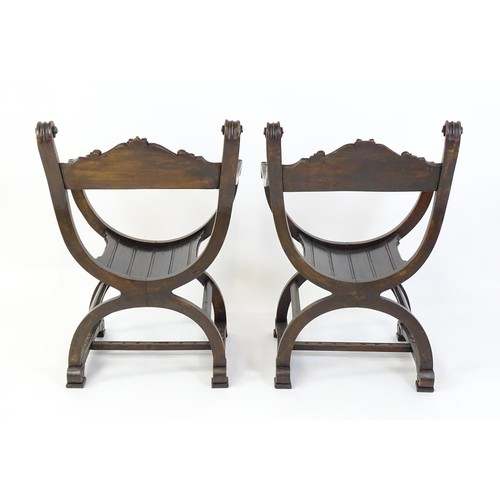 1703 - Two late 19thC / early 20thC Savonarola chairs, the uprights of scrolled form with carved mask detai... 