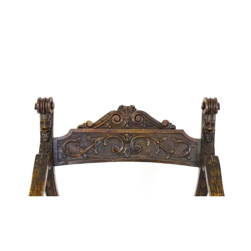 1703 - Two late 19thC / early 20thC Savonarola chairs, the uprights of scrolled form with carved mask detai... 