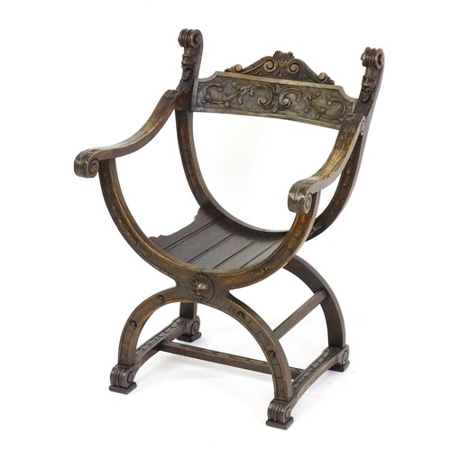 1703 - Two late 19thC / early 20thC Savonarola chairs, the uprights of scrolled form with carved mask detai... 