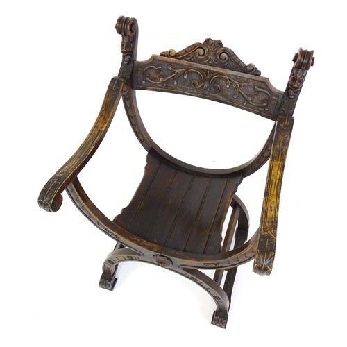 1703 - Two late 19thC / early 20thC Savonarola chairs, the uprights of scrolled form with carved mask detai... 