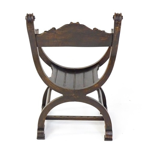 1703 - Two late 19thC / early 20thC Savonarola chairs, the uprights of scrolled form with carved mask detai... 