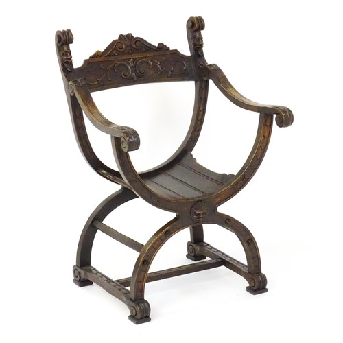 1703 - Two late 19thC / early 20thC Savonarola chairs, the uprights of scrolled form with carved mask detai... 