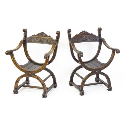 1703 - Two late 19thC / early 20thC Savonarola chairs, the uprights of scrolled form with carved mask detai... 