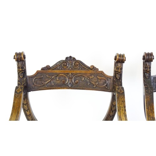 1703 - Two late 19thC / early 20thC Savonarola chairs, the uprights of scrolled form with carved mask detai... 