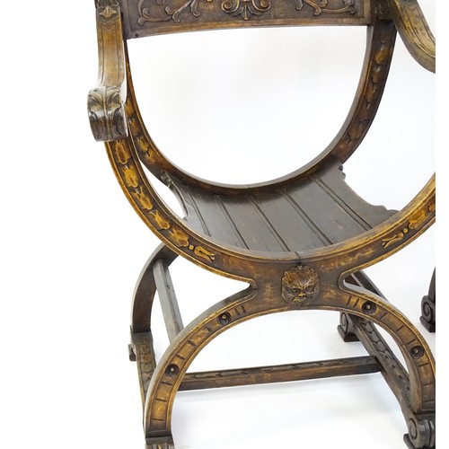 1703 - Two late 19thC / early 20thC Savonarola chairs, the uprights of scrolled form with carved mask detai... 