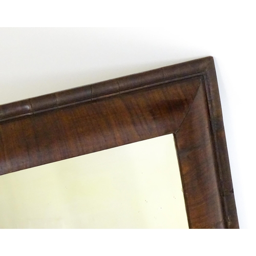 1728 - A late 18thC / early 19thC cushion mirror with a moulded walnut frame. 22