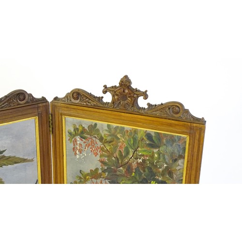 1730 - A late 19thC / early 20thC walnut two fold screen with a floral carved pediment and two canvas panel... 