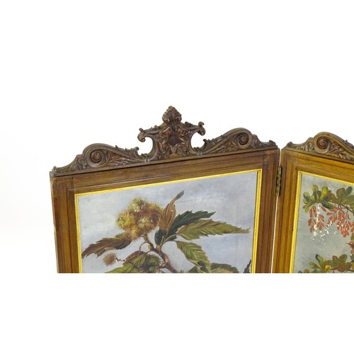 1730 - A late 19thC / early 20thC walnut two fold screen with a floral carved pediment and two canvas panel... 