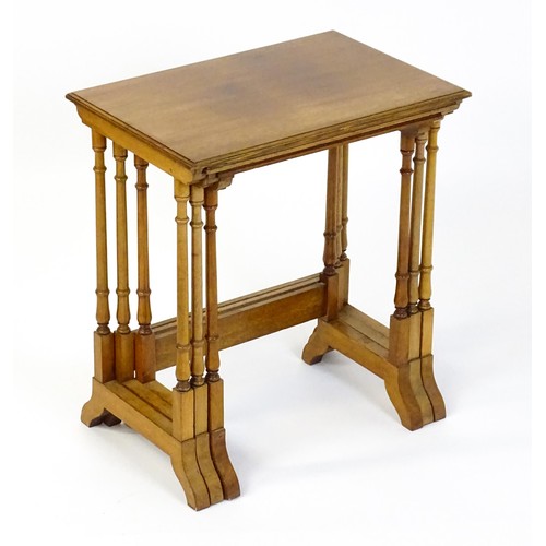 1741 - A nest of three early 20thC walnut tables each with a rectangular top, four turned pillar supports a... 